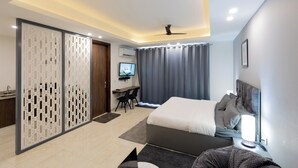 Une chambre d’hôtel moderne équipée d’un lit, d’un bureau et d’une télévision.