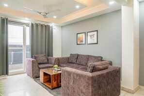 A modern living room with a grey sofa set, a wooden coffee table, and a ceiling fan.