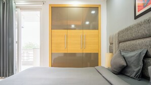 A bedroom with a bed, a wardrobe, and a headboard. - Housr 3 BHK Apartment Sector 45 Gurgaon (Gurugram)
