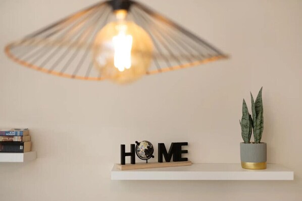 A shelf with a potted plant and a sign that reads 'HOME' on a wall.