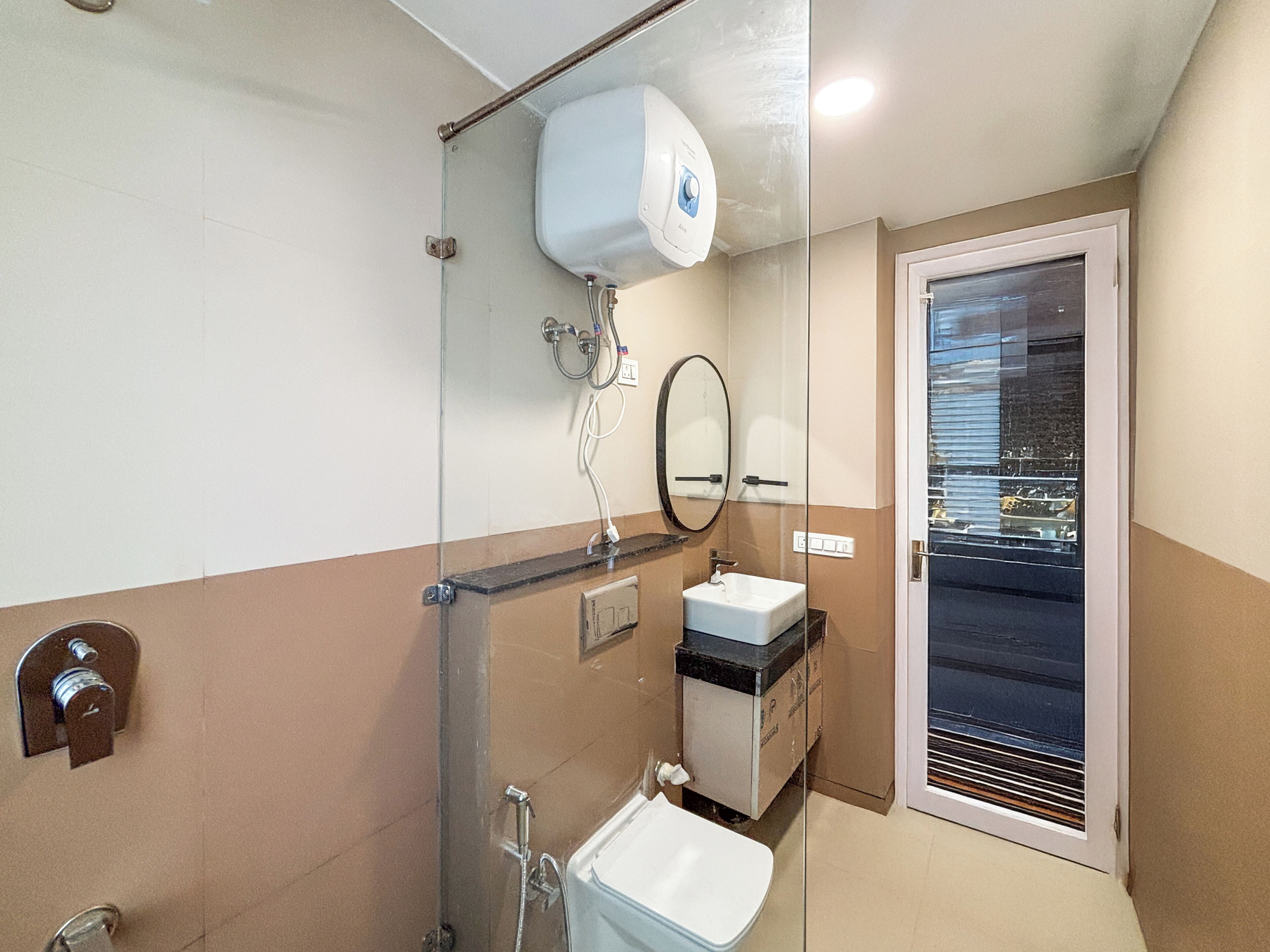 A bathroom with a glass shower enclosure, a sink, a mirror, and a window with blinds.