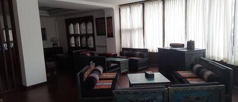 A traditional living room with patterned sofas, a coffee table, and a cabinet.