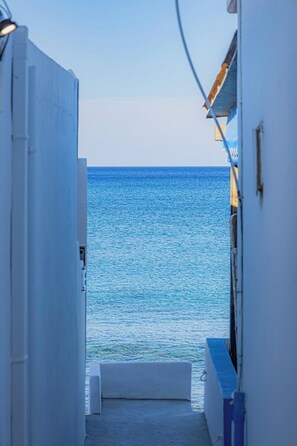A narrow corridor leading to a balcony overlooking a calm sea.