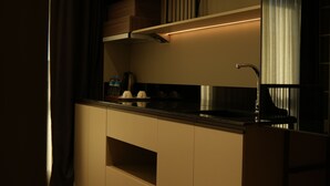 A modern kitchen with built-in appliances, wooden cabinets, and a stainless steel sink. - Arun Suites (Gaziantep)