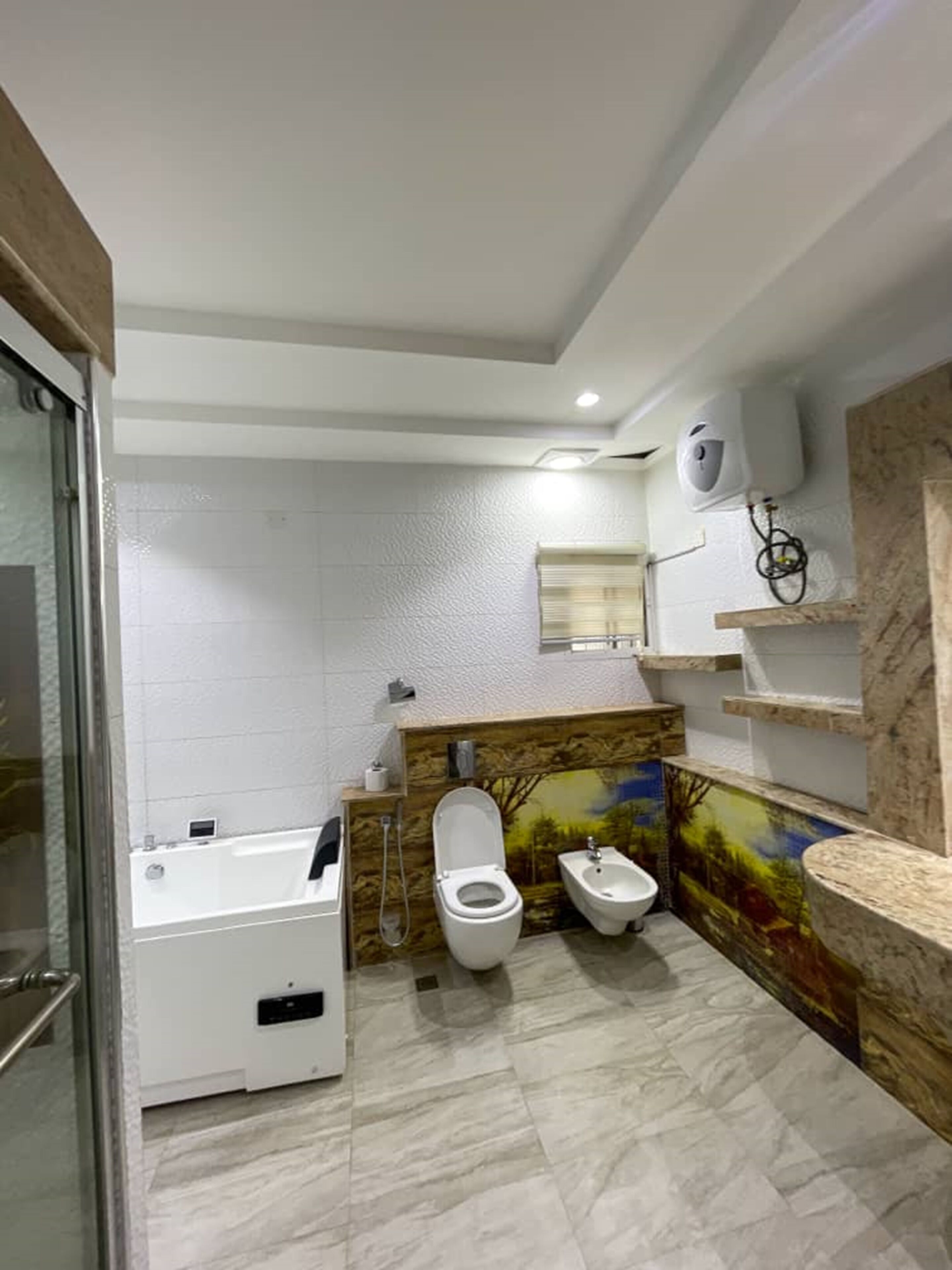 A modern bathroom with a bathtub, toilet, bidet, and a shower.