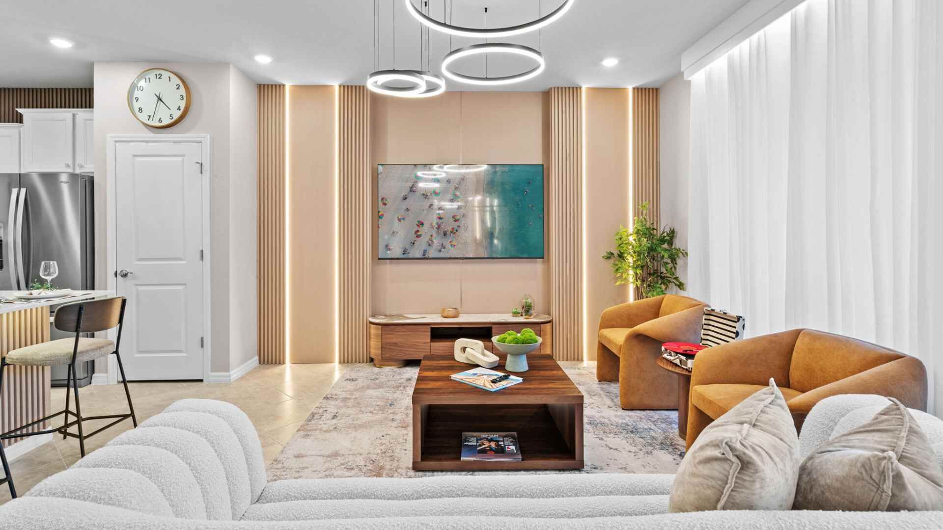 A modern living room with a sofa, coffee table, and a TV mounted on the wall.