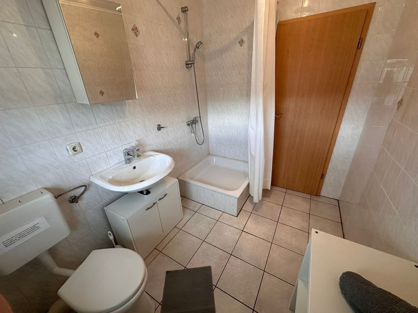 A bathroom with a toilet, sink, shower, and bathtub.