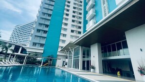 Un hotel moderno con piscina, edificios altos y cielo despejado.