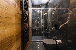 Een douche, handdoeken, shampoo, toiletpapier