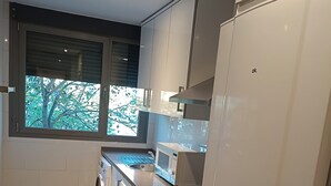 Una cocina moderna con lavadora integrada, horno y un refrigerador grande.