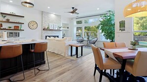 A modern kitchen with a central island, white walls, and a large window. - Relaxing 3BAPool+Hot Tub Near the River & Wineries (Walnut Grove)