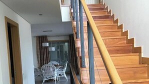 Una escalera de madera con barandillas metálicas que sube a un piso superior.