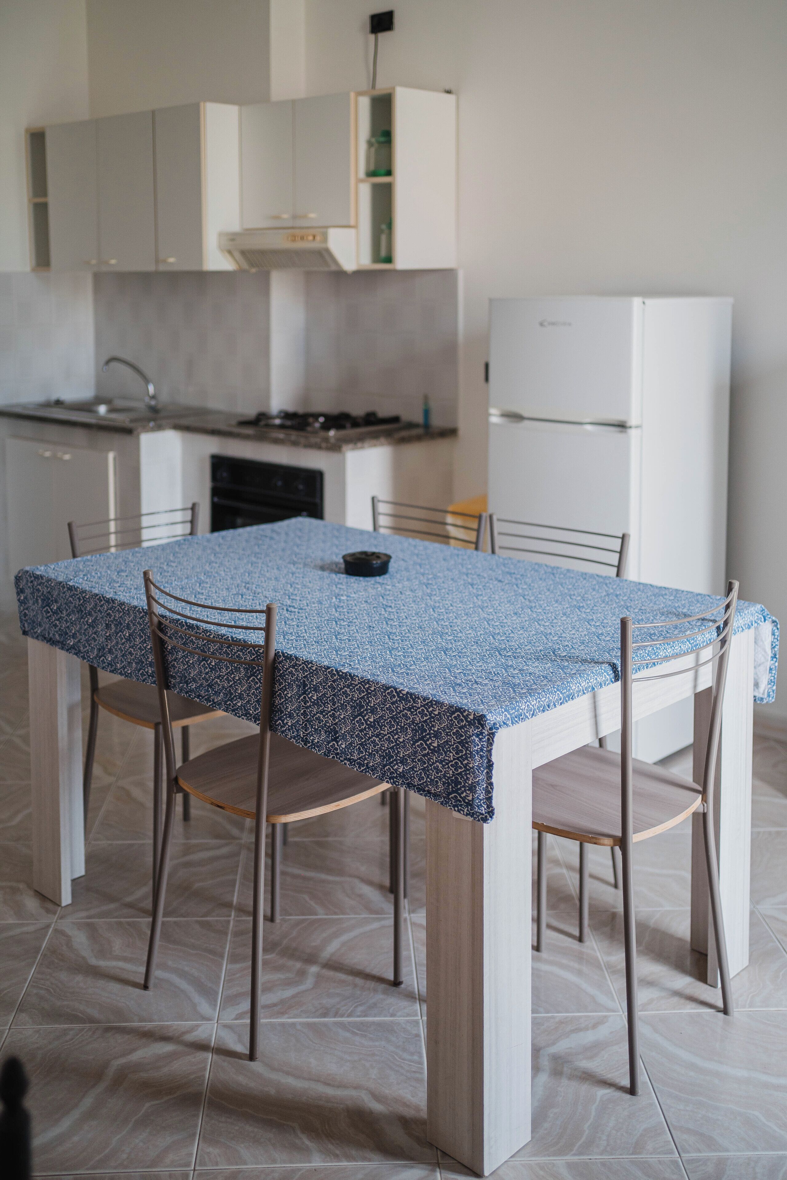 Una cucina moderna con tavolo, sedie e frigorifero.