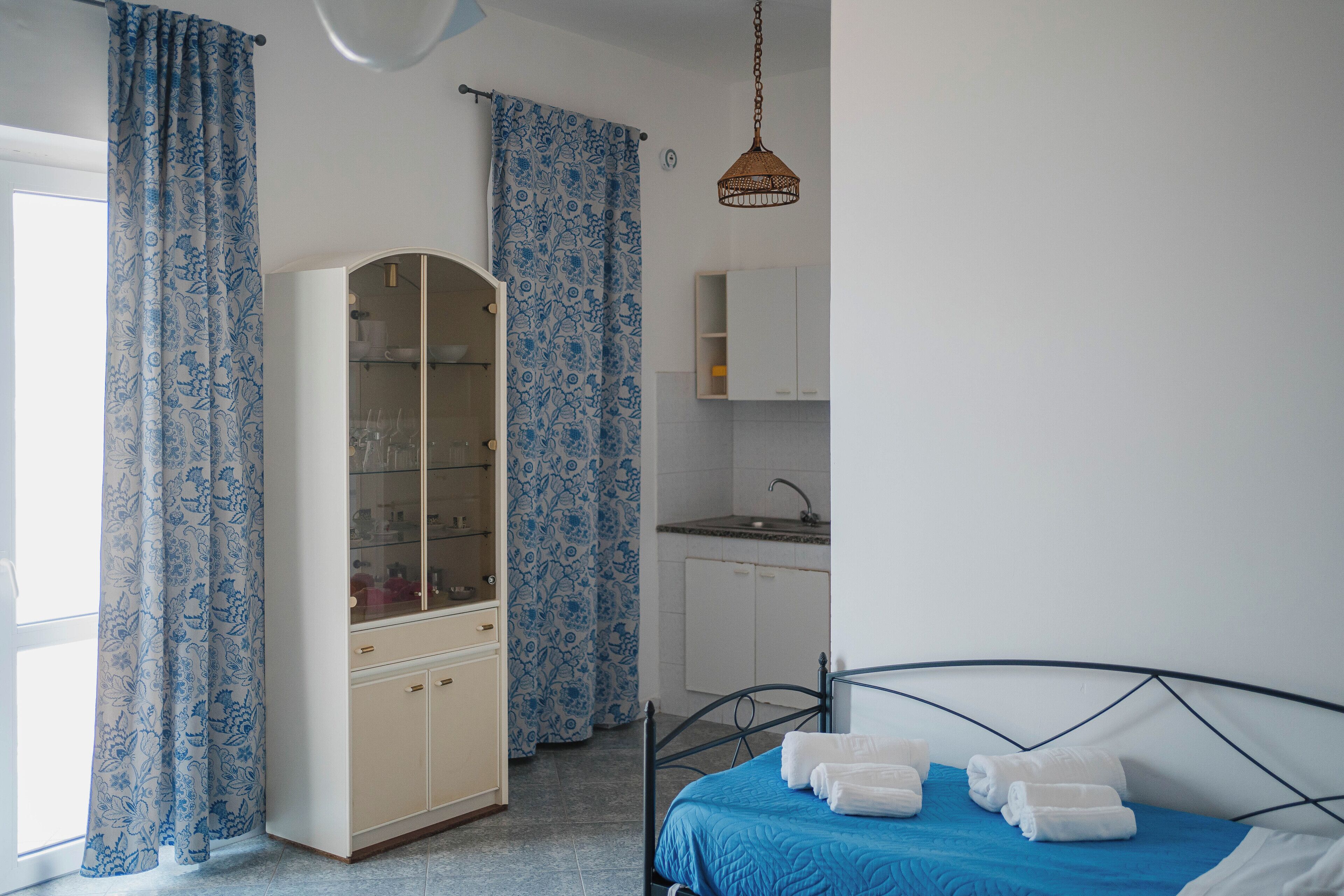 Ein Schlafzimmer mit Bett, Kleiderschrank, Bad und einer Küchenzeile.