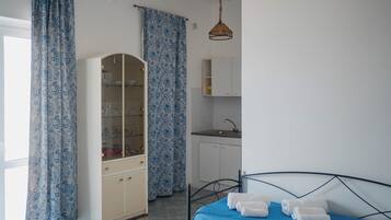 Ein Schlafzimmer mit Bett, Kleiderschrank, Bad und einer Küchenzeile.
