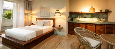 A bedroom with a wooden bed, bedside lamps, a nightstand, a wicker chair, and a small table.