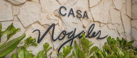A stone wall with the words "CASA" and "Nogales" in black lettering.