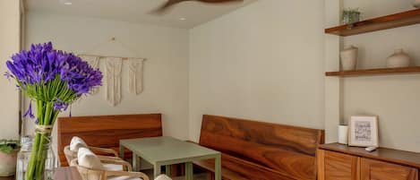 A modern living room with a wooden bench, a small table, and a cabinet.
