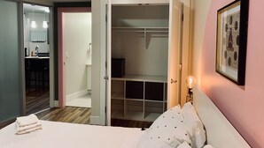 Un dormitorio con cama, armario, baño y comedor.
