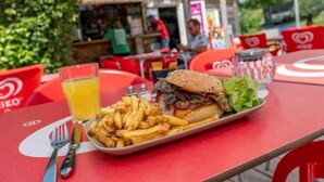 A meal consisting of a burger, fries, and a drink on a red table with a white placemat. - ZEcamping 3* piscine chauffée hammam sauna locatif TV 47m2 6 pers (Verruyes)