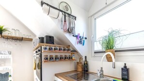 A kitchen with a wooden countertop, a stainless steel sink, and various kitchen utensils and appliances. - Premium Suite - Forest view - Balcony - Black Forest (Bühl)
