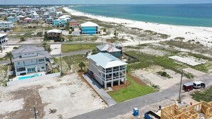 Zona residencial costera con casas, una playa y cielo despejado.
