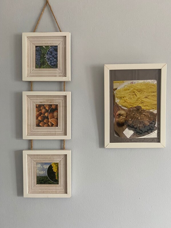 A wall with four square frames arranged vertically, each containing different items.