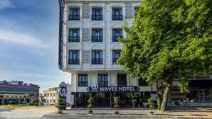 Un hotel con un letrero que dice "WAVES HOTEL" y "AIRPORT", indicando su cercanía a un aeropuerto.