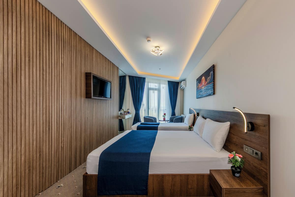 Deluxe trippelrum - utsikt mot staden | Sängtillbehör av högsta kvalitet, minibar och skrivbord
