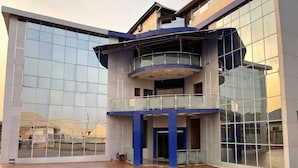 Un edificio moderno con fachada de vidrio, un atrio central y un elemento circular en el suelo.