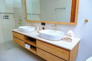 A modern bathroom with two sinks, a large mirror, and a wooden vanity with storage drawers. - Villa Moon Orchid - 3 bedroom villa (Denpasar)