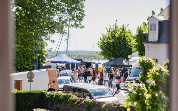 A crowded outdoor event with tents and parked cars.