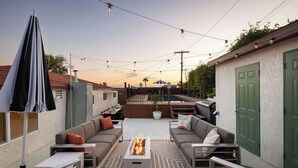 An outdoor patio with a fire pit, seating area, and string lights. - Pool & Palmz|Hot Tub|Fire Pit|Chefs Kitchen|6 beds (San Diego)