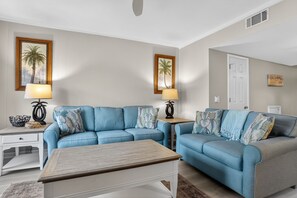 A living room with two sofas, a coffee table, and two lamps.