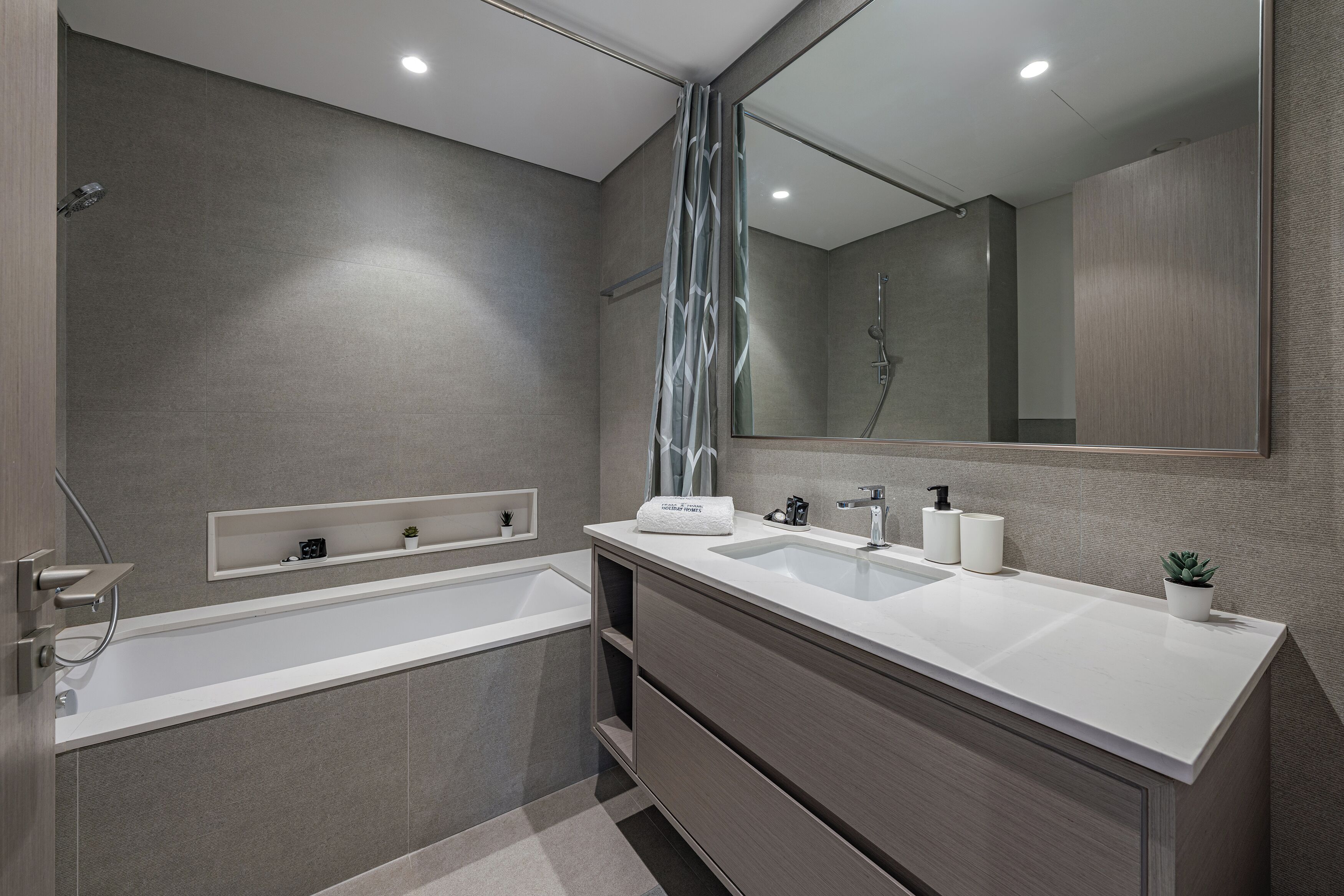 Een moderne badkamer met een groot bad, een wastafel met twee kommen en een douche.