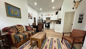 Una sala de estar con un sofá a rayas, una mesa de centro de madera y un tapete estampado.