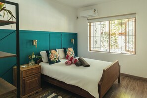 A bedroom with a bed, a nightstand, a window with bars, and a wall-mounted air conditioner. - Frida, a 3-room apartment just a few minutes' walk from Blue Bay Lagoon. (Blue Bay)
