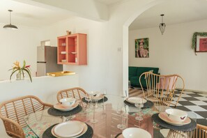 A dining area with a glass table, wicker chairs, and a pink cabinet. - Frida, a 3-room apartment just a few minutes' walk from Blue Bay Lagoon. (Blue Bay)