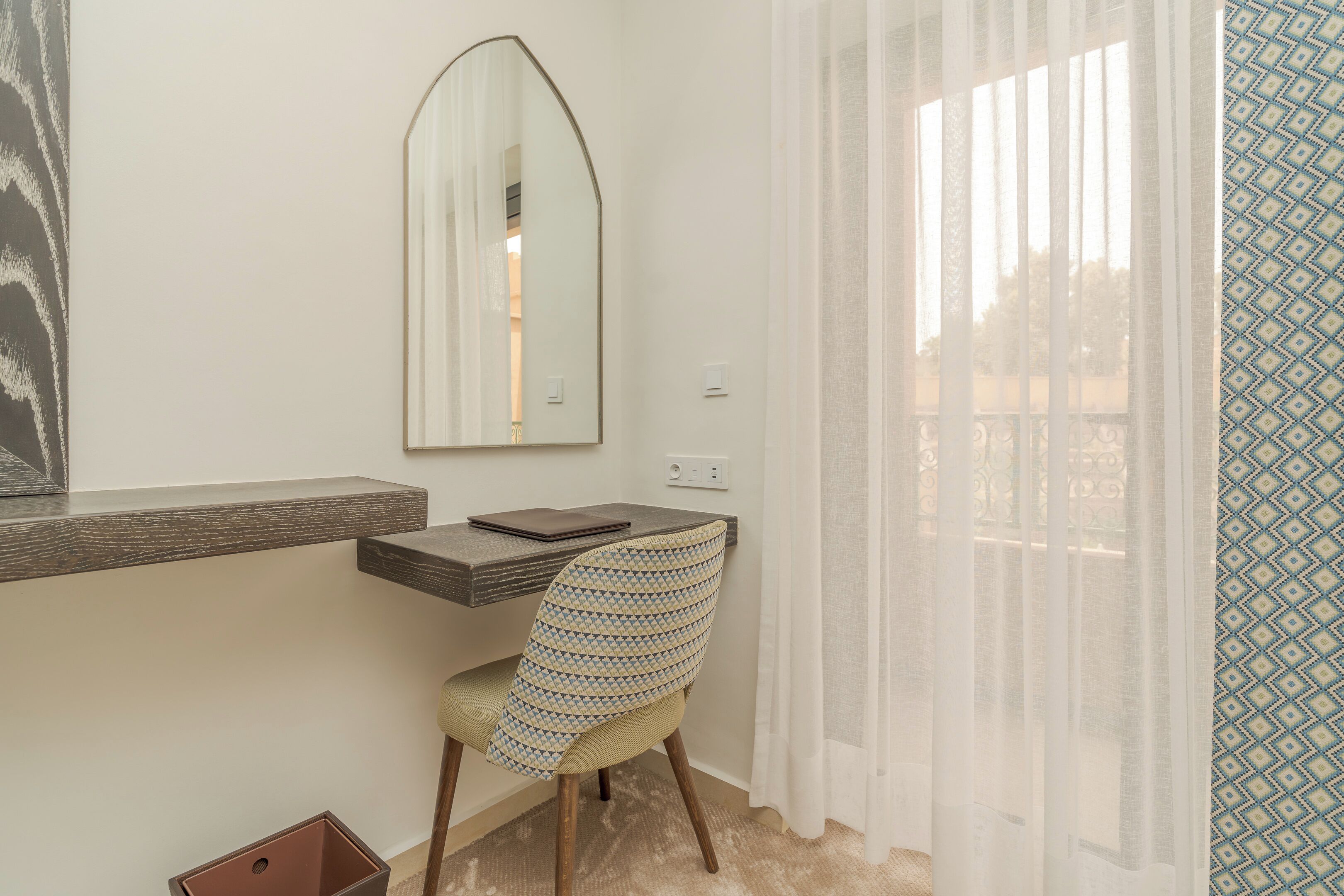 A small, private office with a desk, chair, and a large mirror.