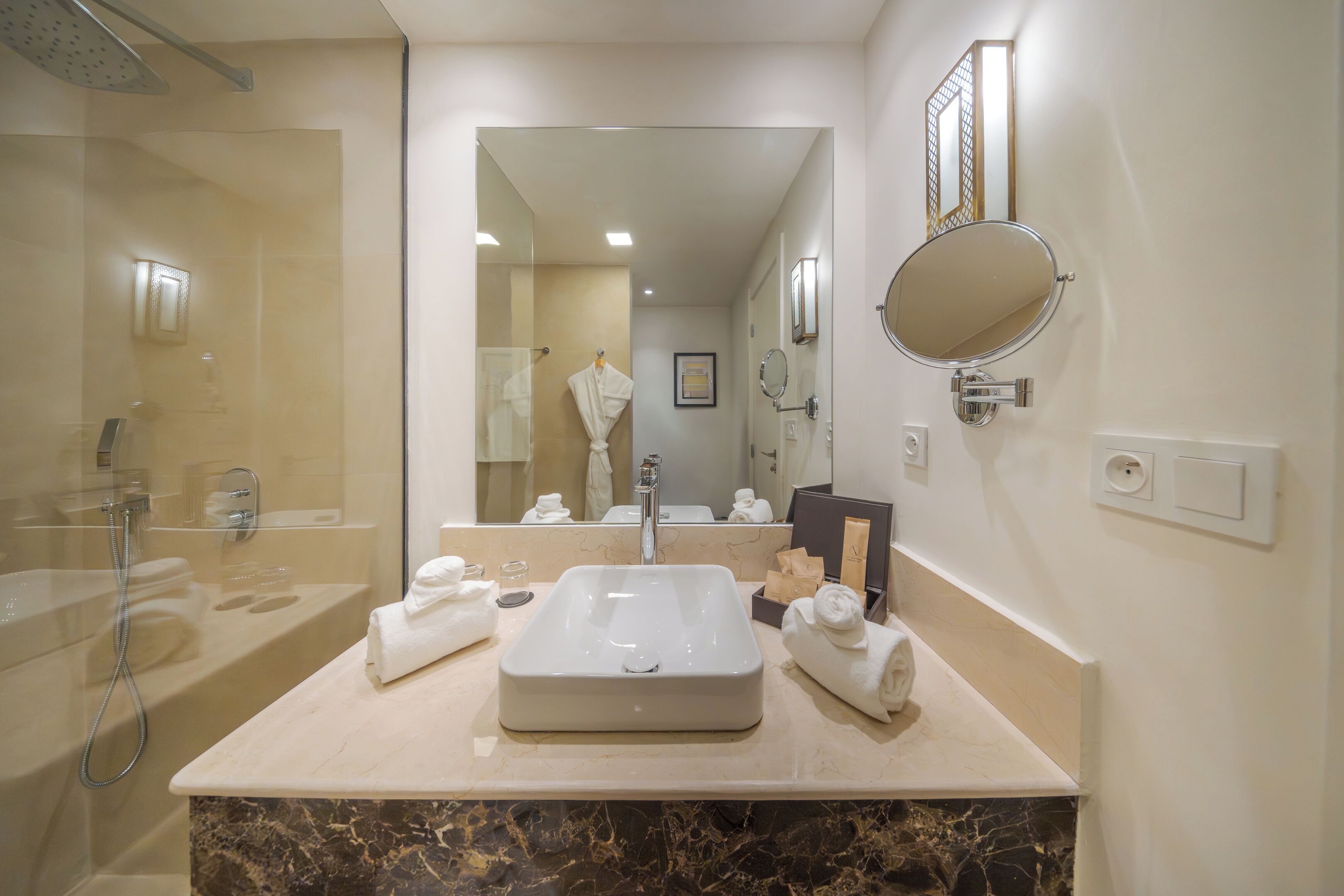 Un bagno moderno con uno specchio grande, un lavandino e una doccia.