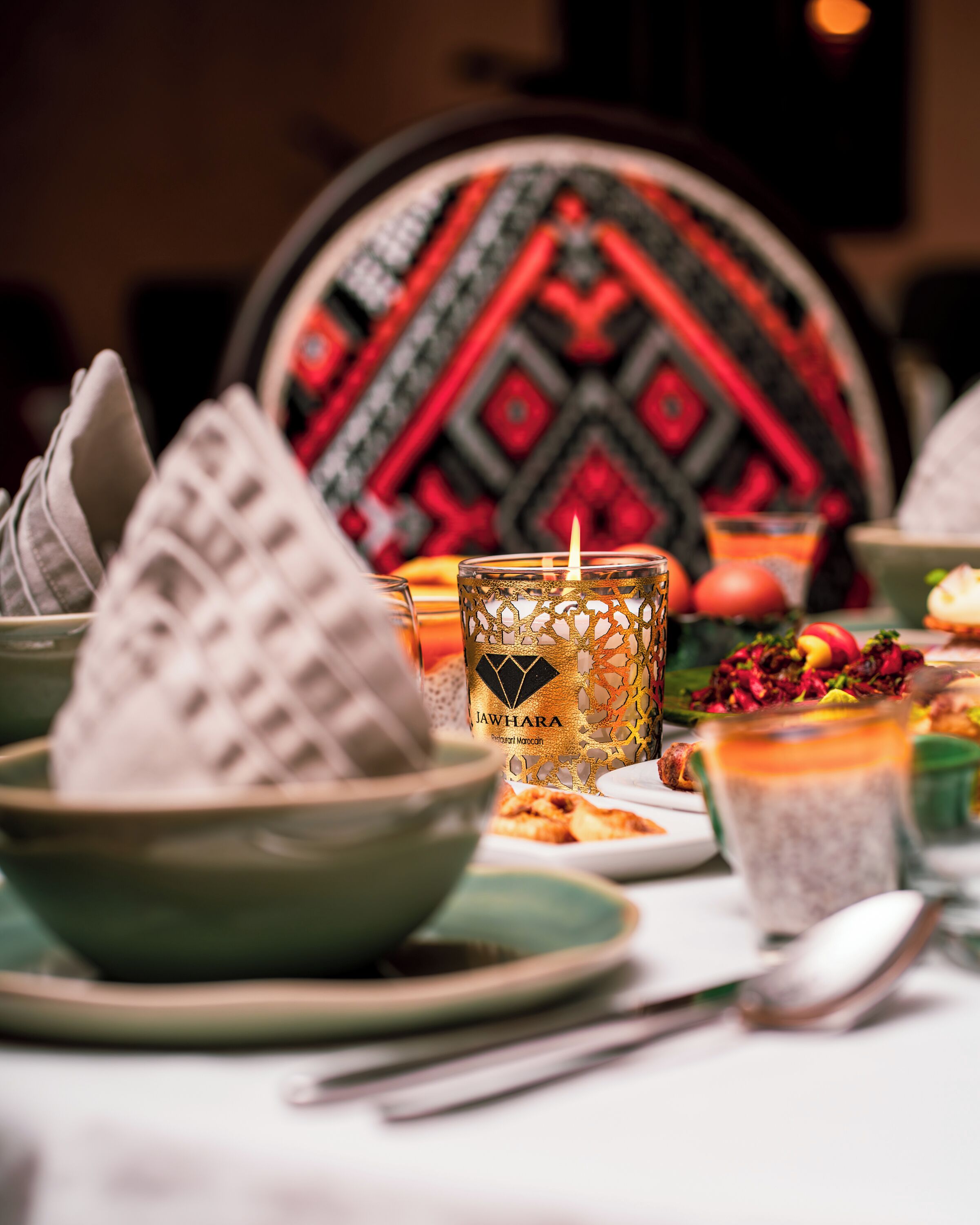 A table set with bowls, a candle, and a glass of tea.