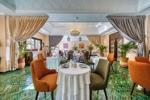 Un comedor con mesas redondas, sillas y plantas en macetas.