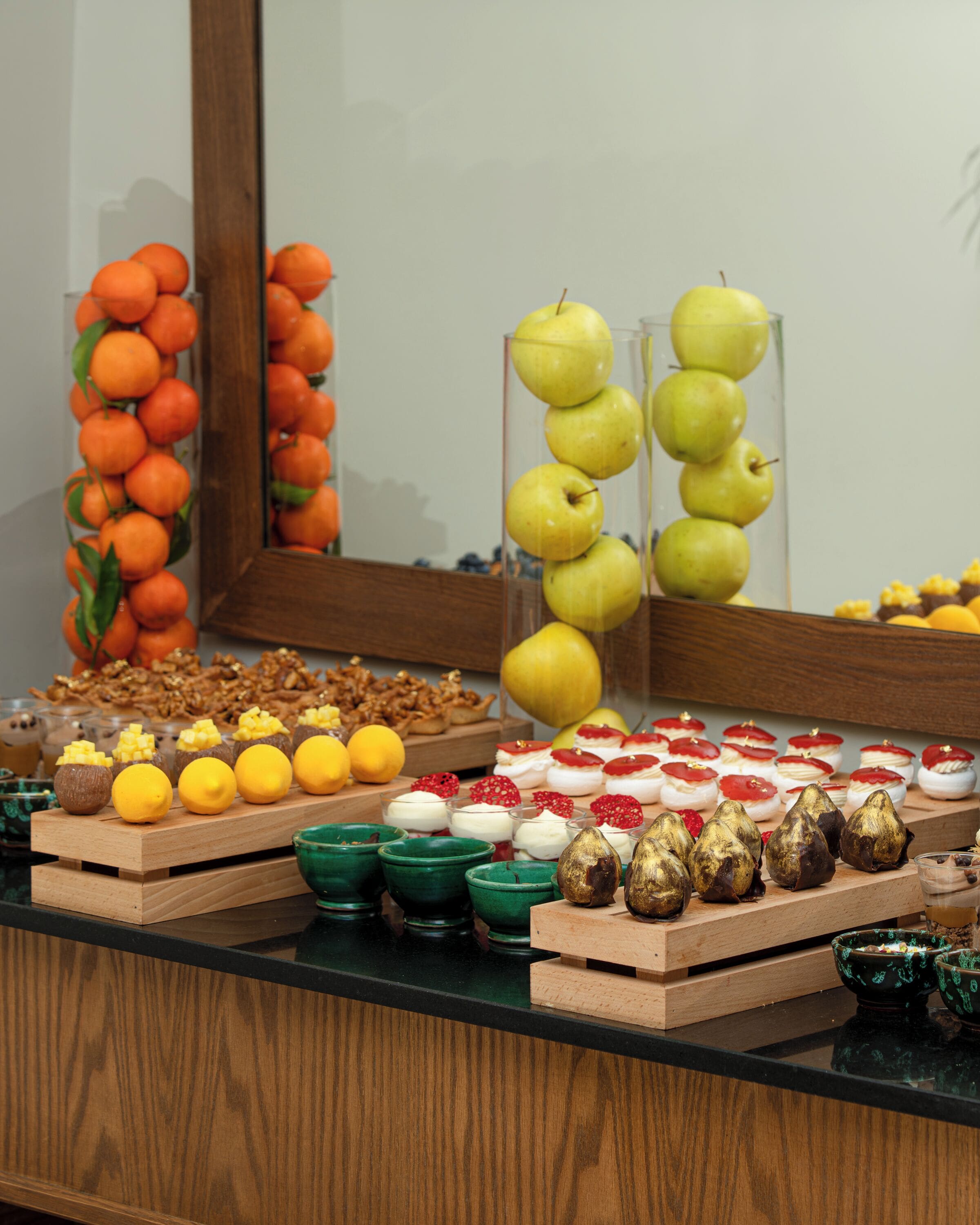 Un buffet proposant une variété de plats, notamment des fruits, des pâtisseries et des desserts.