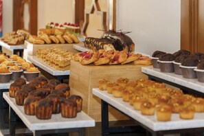 Une variété de produits de boulangerie présentés sur des tables dans une boulangerie.