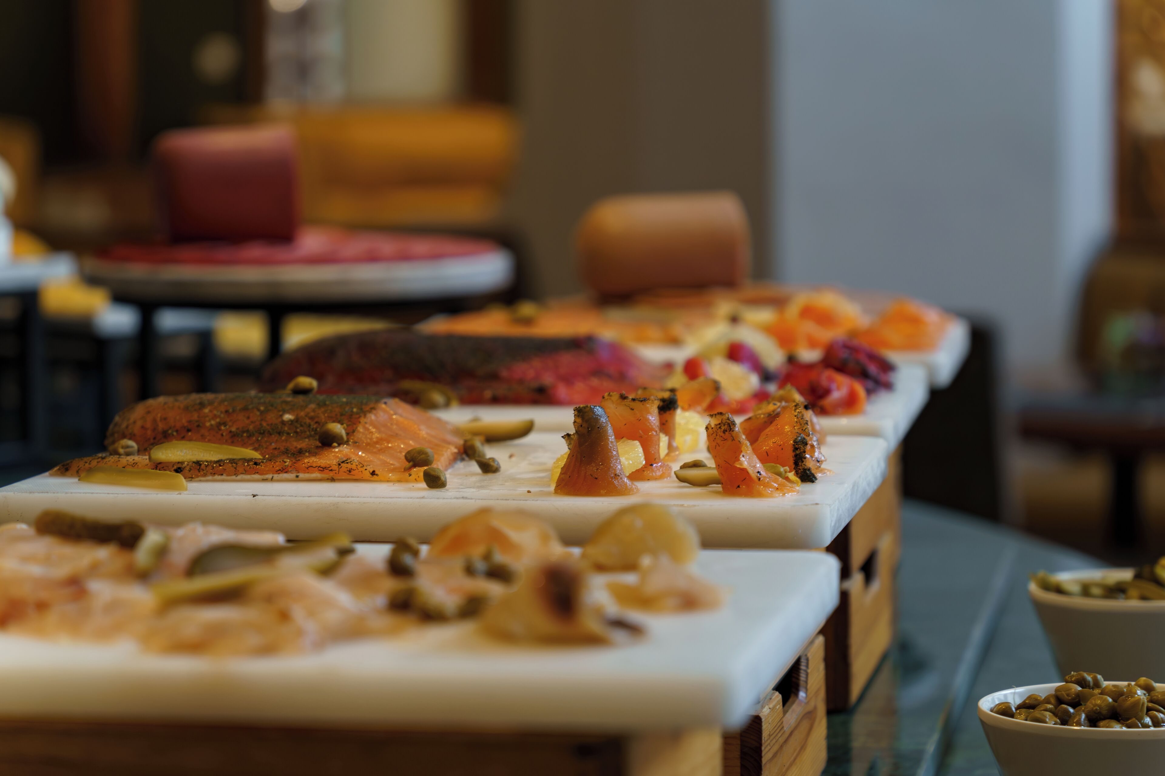 Un buffet proposant divers plats, notamment du saumon et des légumes.