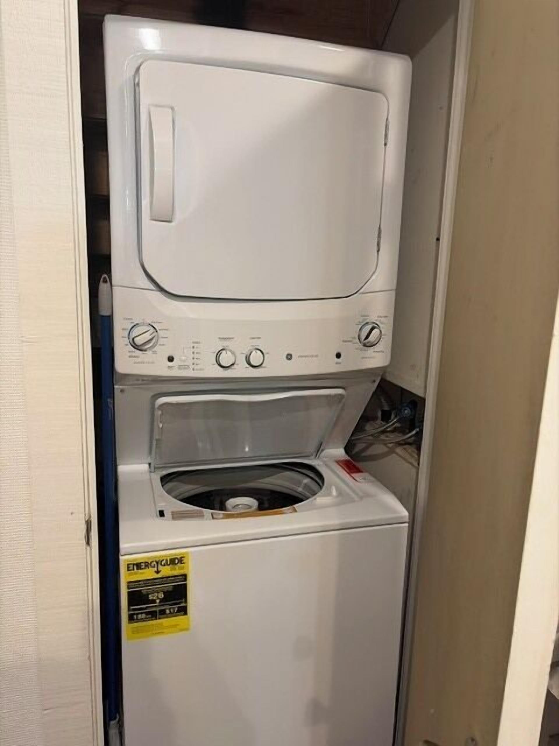 A compact washer and dryer unit with a control panel and a yellow energy efficiency label.