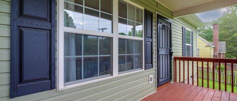 A house with a porch, large windows, and a door.