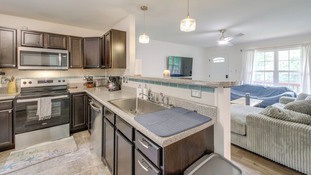 A modern kitchen with dark cabinetry, stainless steel appliances, and a granite countertop. - Commuter-friendly Home: 3 Mi to Dtwn Knoxville! (Knoxville)