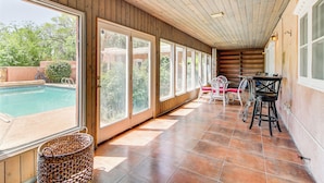 A covered patio area with a pool, large windows, and outdoor furniture. - 3 Mi to Zoo & Garden: ABQ Home w/ Private Pool! (Albuquerque)