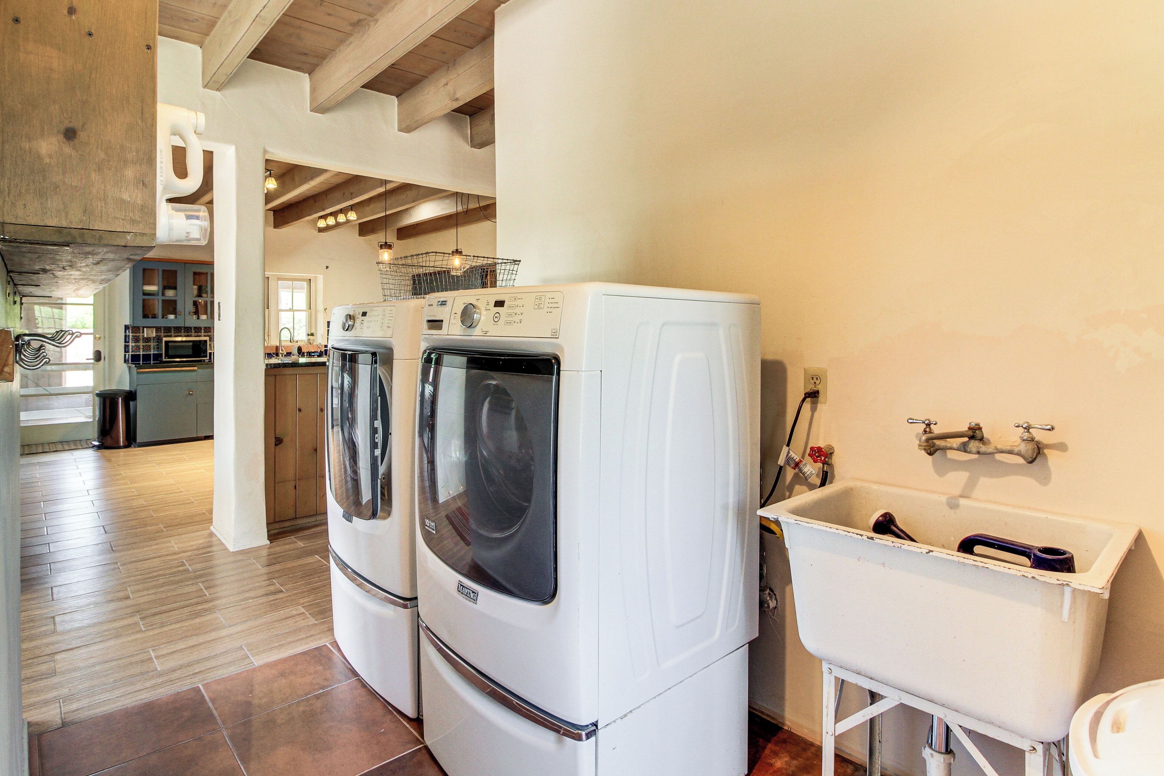 A laundry area with two front-loading washing machines and a white sink.